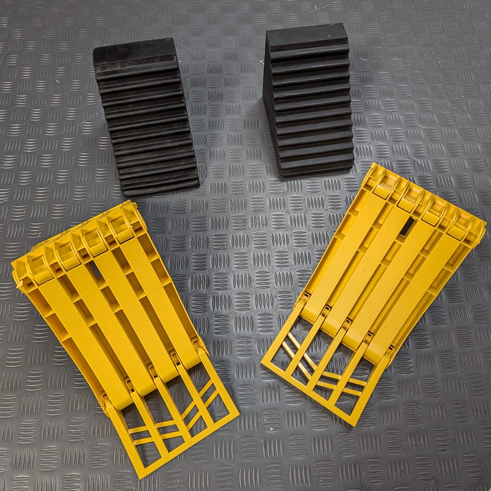 Image shows bright yellow foldable wheel chocks and black rubber wheel chocks