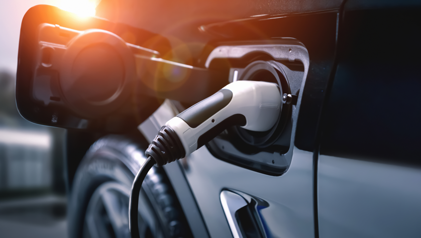 Image shows an electric vehicle charging port with a charger plugged in