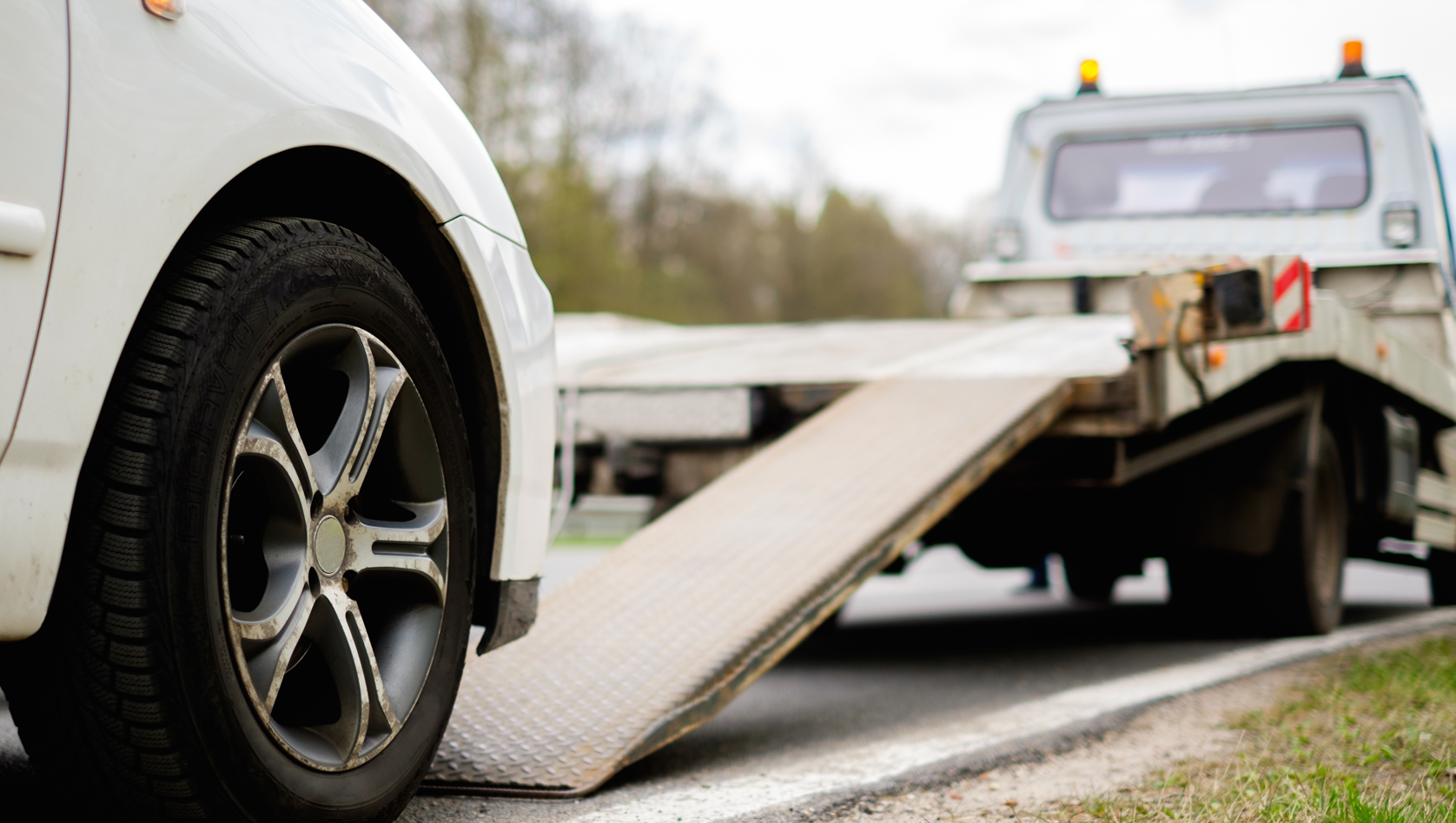 Image shows a recovery truck preparing to load a car