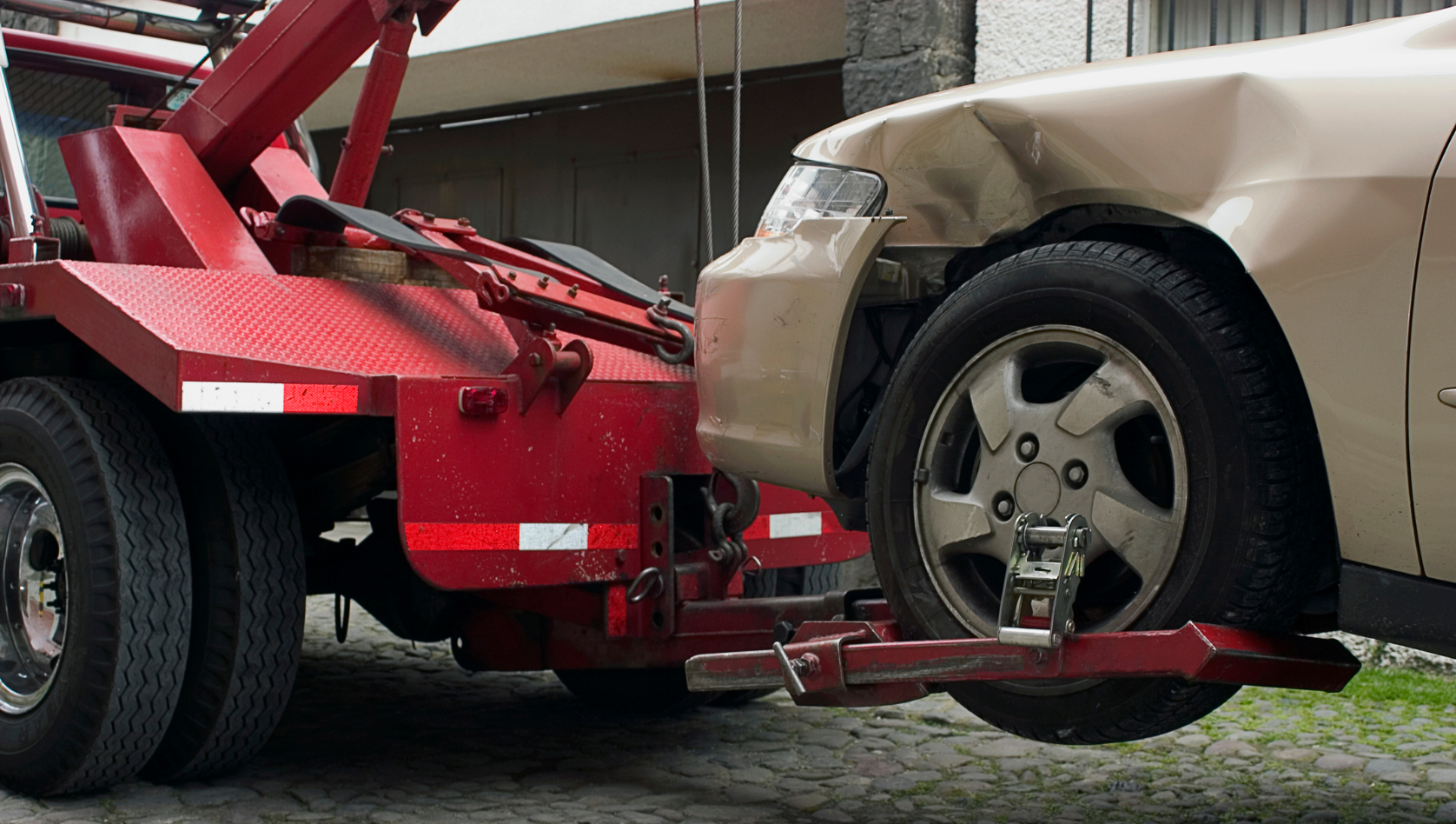 Image shows a damaged car being towed. Image depicts T&C Services towing equipment range