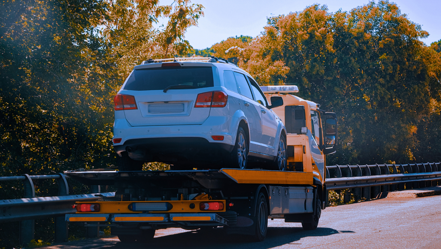 mage shows an SUV on the back of a recovery truck. Image depicts preparing your recovery kit for autumn